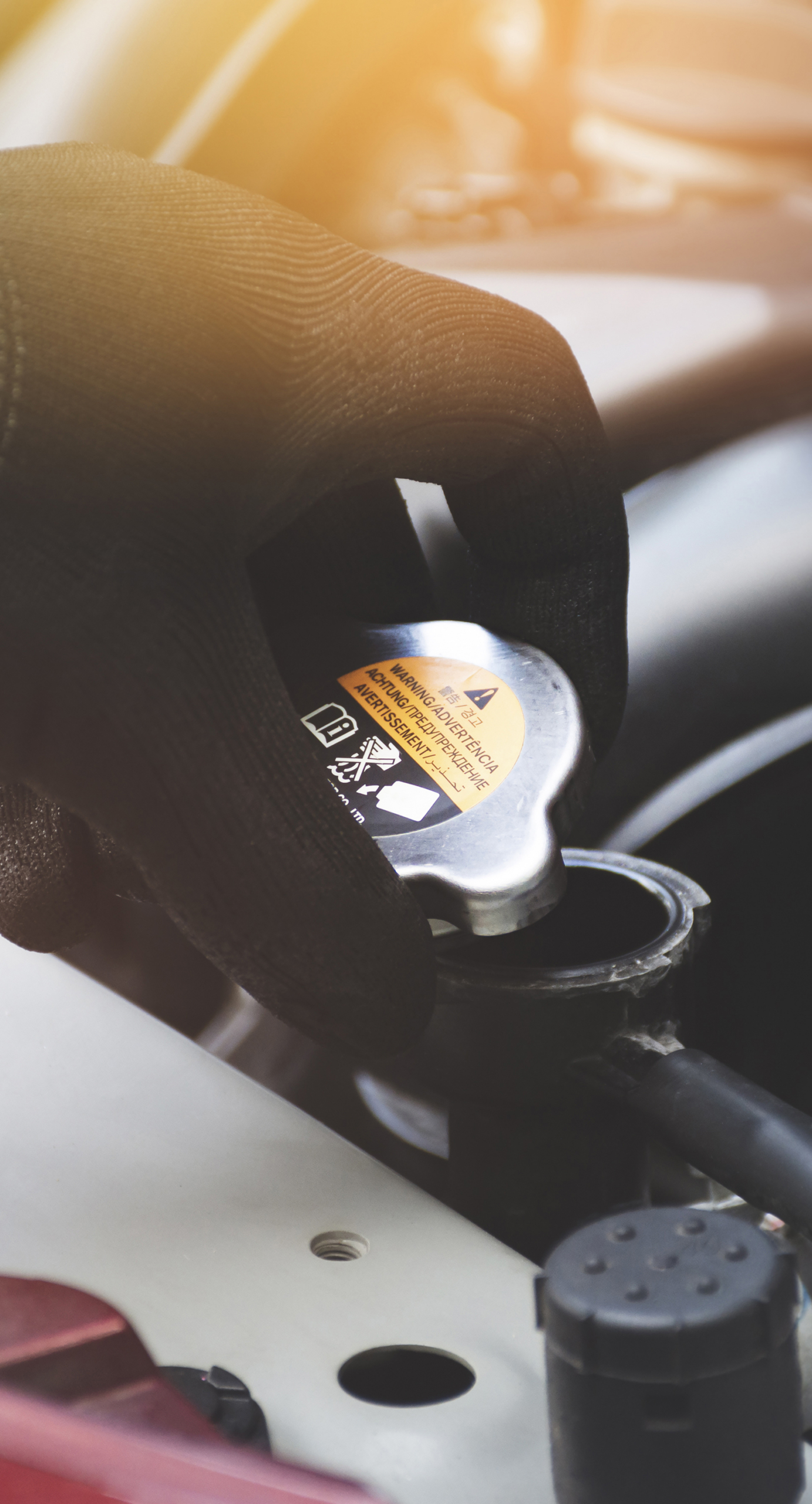 Mechanic hand was opening the radiator cap to check the coolant level